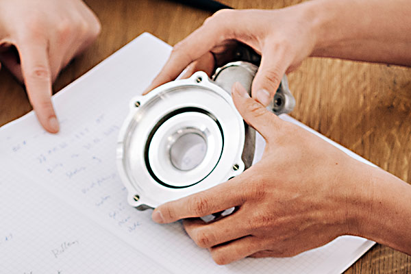 CE-Kennzeichnung Ingenieur hält ein Metallobjekt.