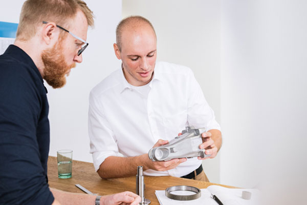 Prototypen Zwei Ingenieure betrachten prüfend einen Prototypen